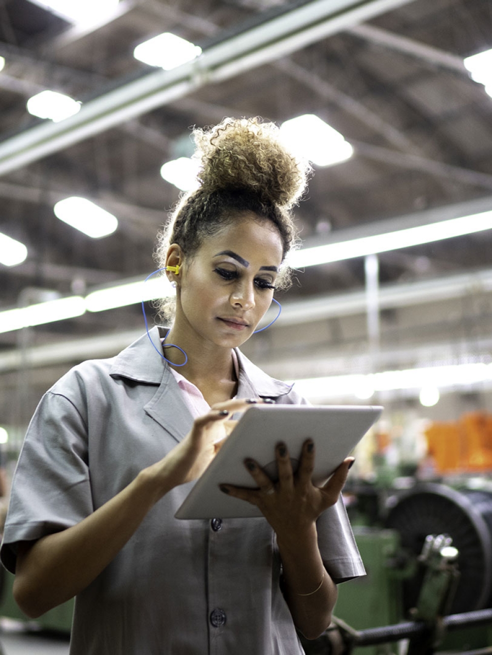 femme dans une usine utilisant une tablette électronique